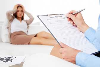 Close-up of a psychologist filling out a psychiatric evaluation report for impulse control concerns