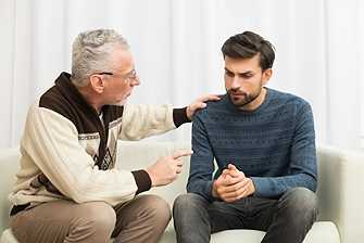 Older man offering emotional support to a younger man during a mental health discussion
