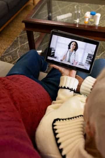 caucasian-senior-couple-having-video-call-with-doctor-sunny-living-room_13339-351039